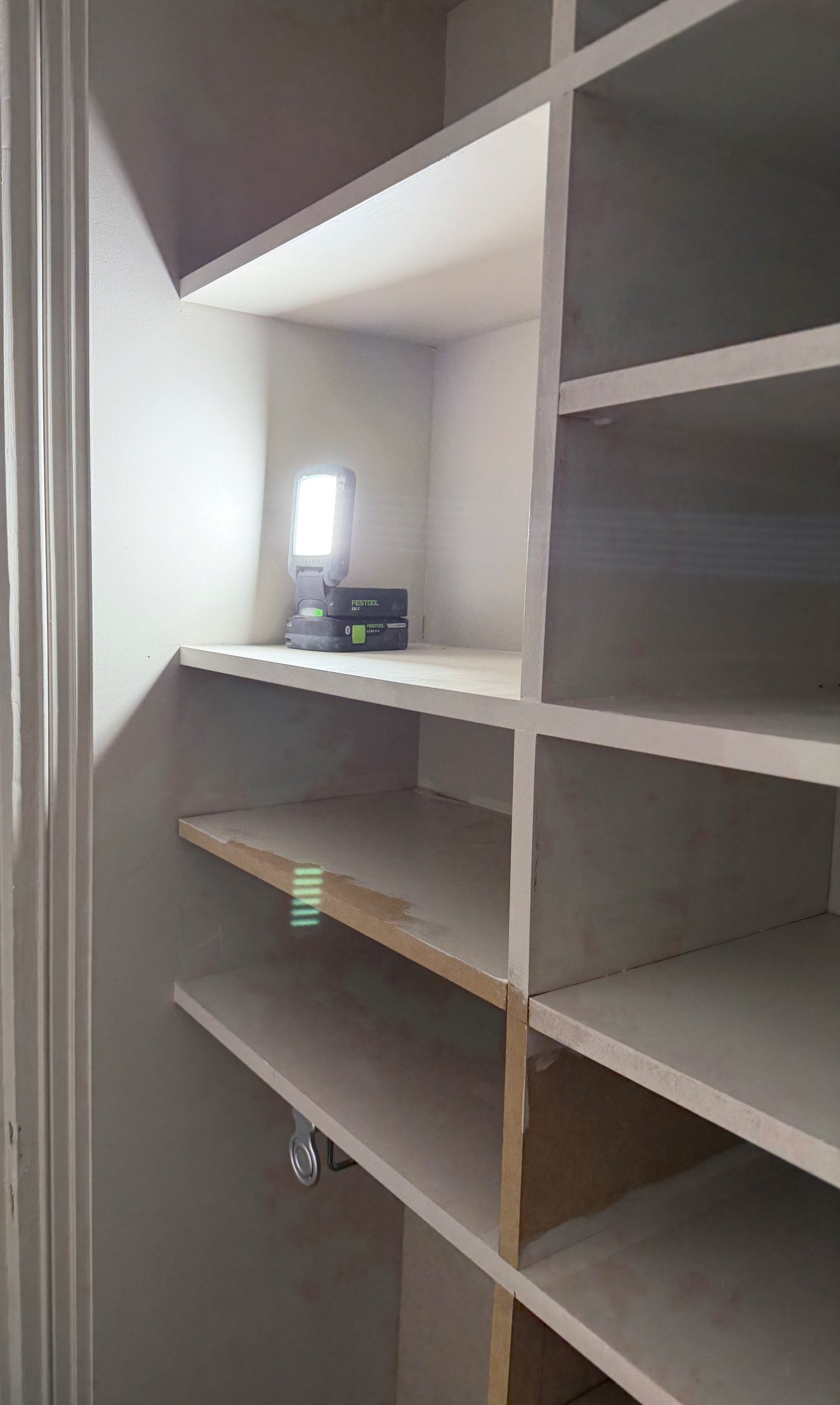 Casiers en medium peints en blanc à l'intérieur du placard