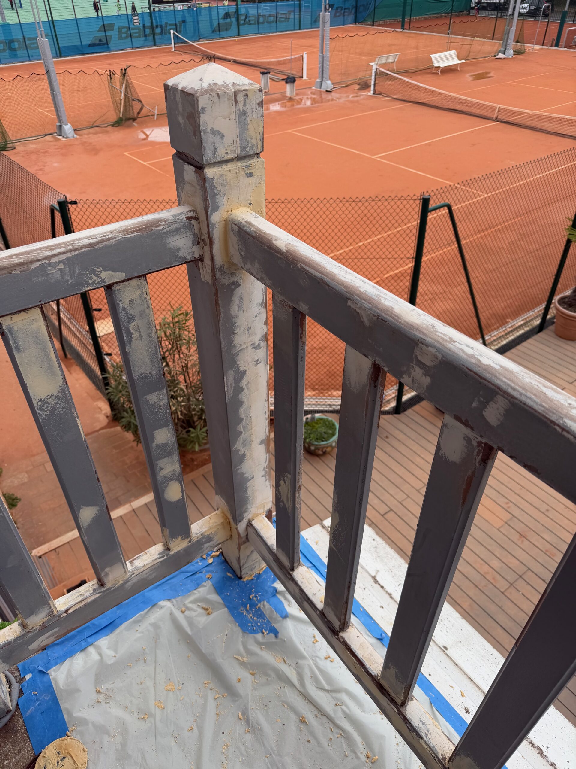 Balustrade en bois vue en angle pendant les travaux de ponçage et de préparation, club de tennis Saint-Mandé