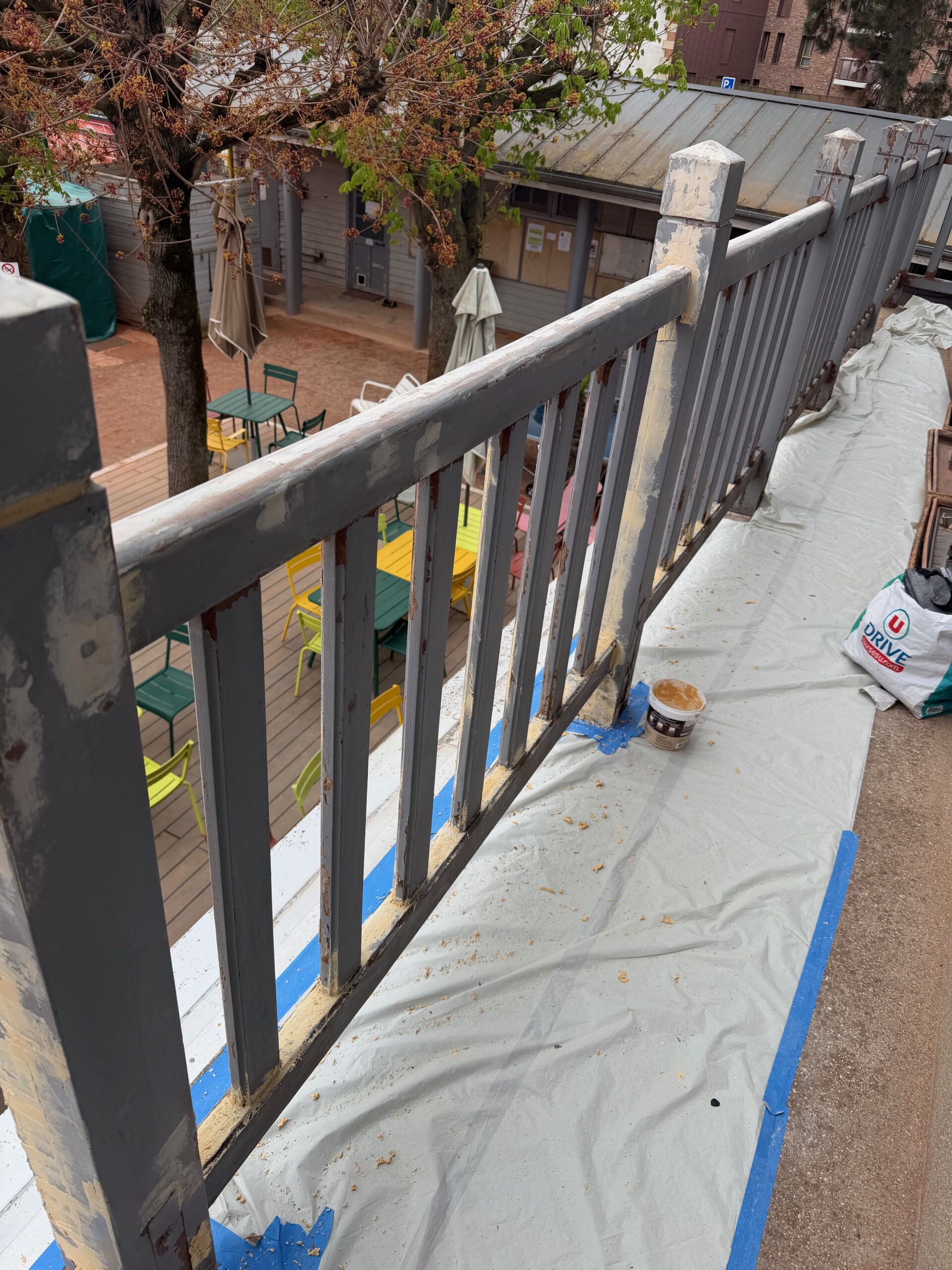 Pilier et vue de face de la balustrade en bois pendant les travaux de ponçage et de préparation, club de tennis Saint-Mandé