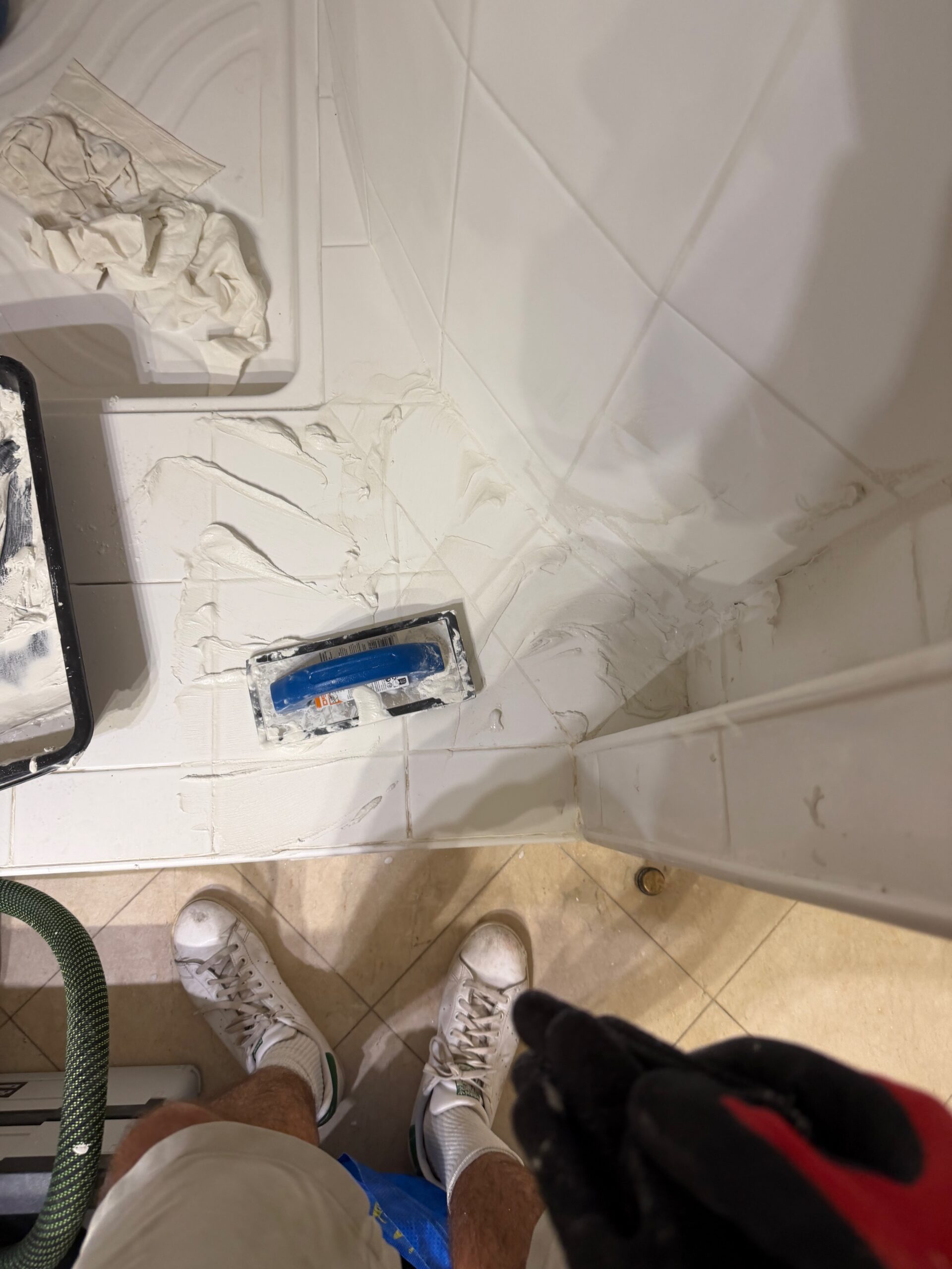 Réfection des joints de carrelage au mortier en cours dans la douche