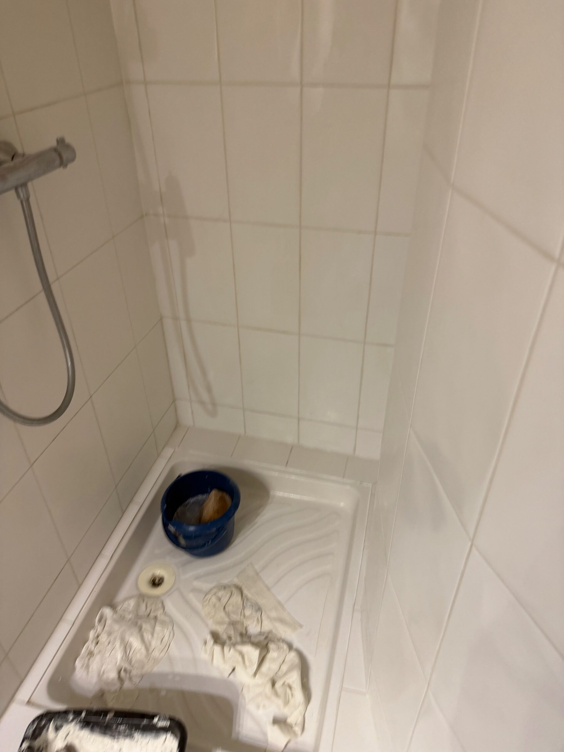Réfection des joints de carrelage au mortier en cours dans la douche