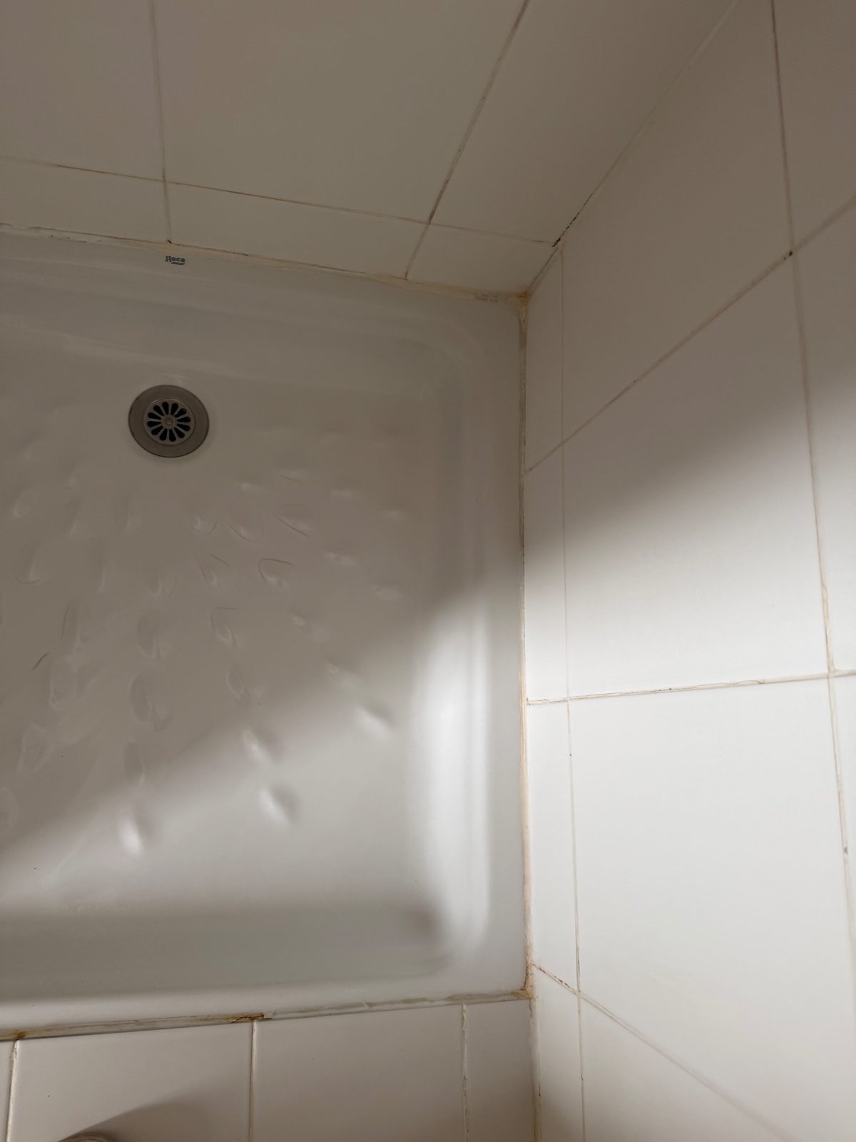 Douche 1 avant intervention : ancien joint silicone jauni autour du bac